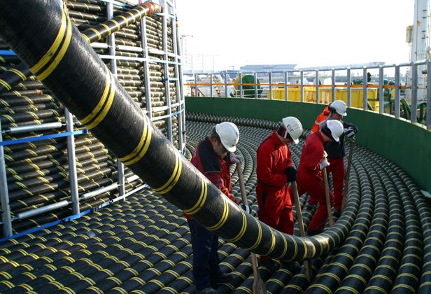 Arbeidere jobber med en kabeltrommel