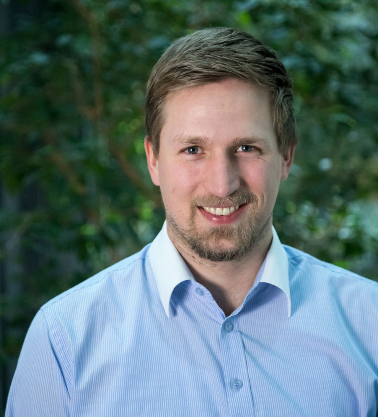 Mann smiler til kameraet