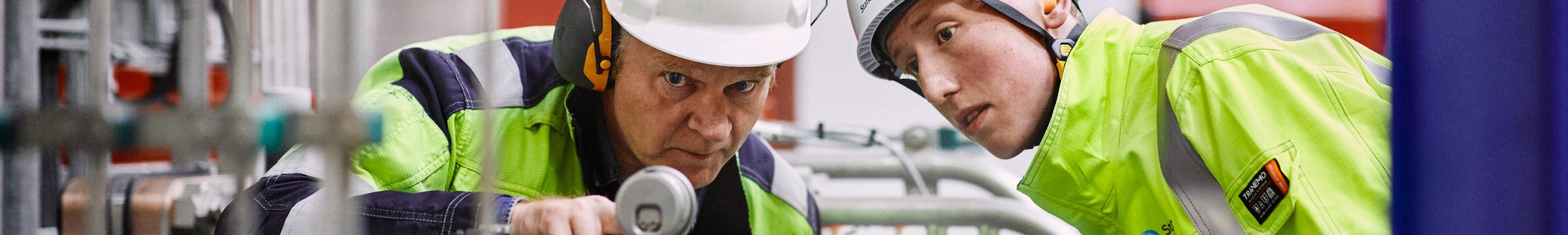 To ansatte ser på utstyr på kraftverket Ringendalen i Norge