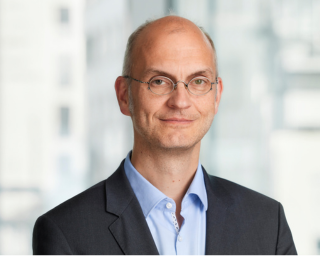 Mann med briller smiler