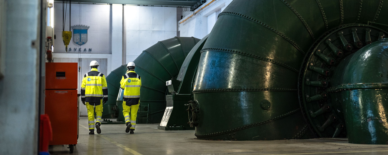 To ansatte på innsiden av et vannkraftverk