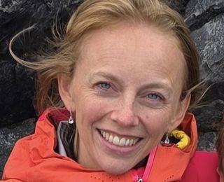 Dame i rød jakke smiler