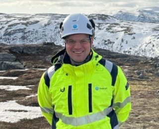 Mann i verneutstyr smiler