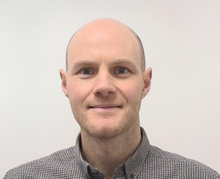 Mann smiler til kameraet