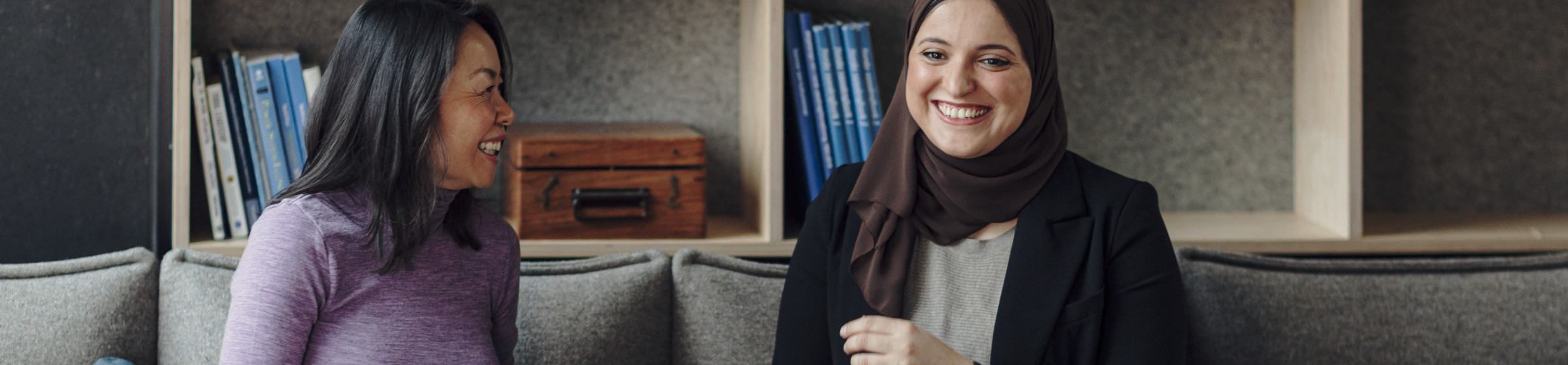 To ansatte snakker sammen og ler