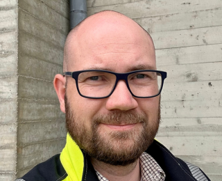 Mann med briller smiler