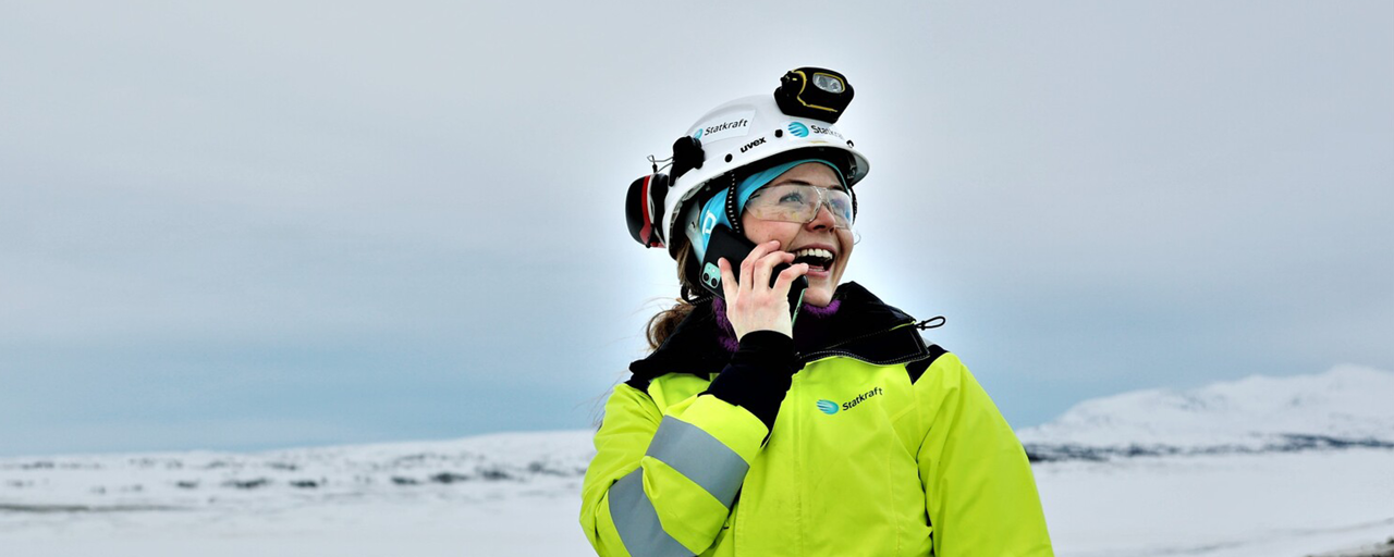 Statkraft-ansatt Siri i arbeidsklær oppe i de snødekte norske fjellene.